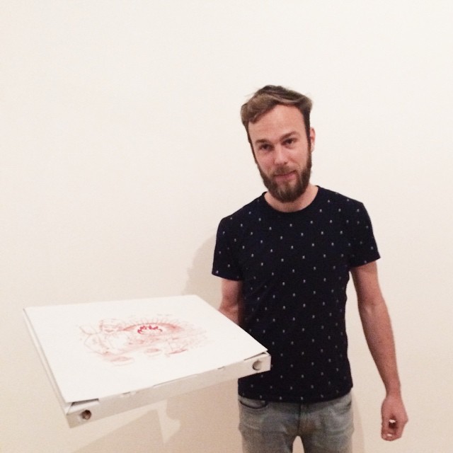 Roel van der Ven holding a pizza in their new home